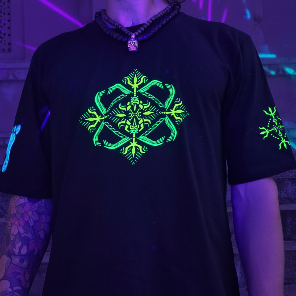 Black t-shirt with green UV reactive design worn by a person in a dark setting