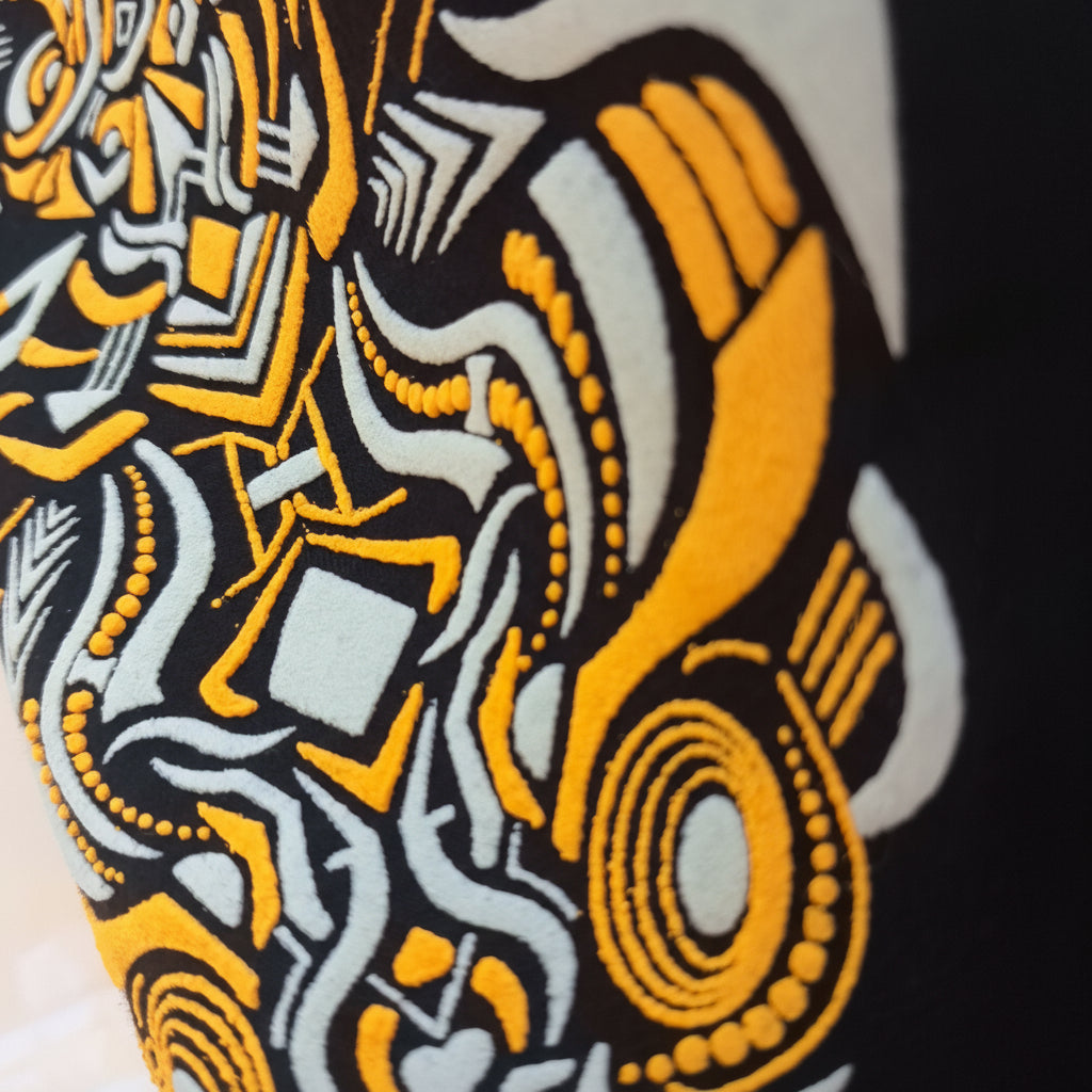 Close-up of a patterned fabric with orange, black, and white design